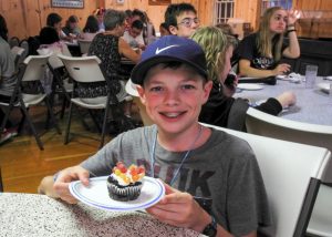 Child with allergies enjoying an allergy-friendly cupcake at Camp Blue Spruce